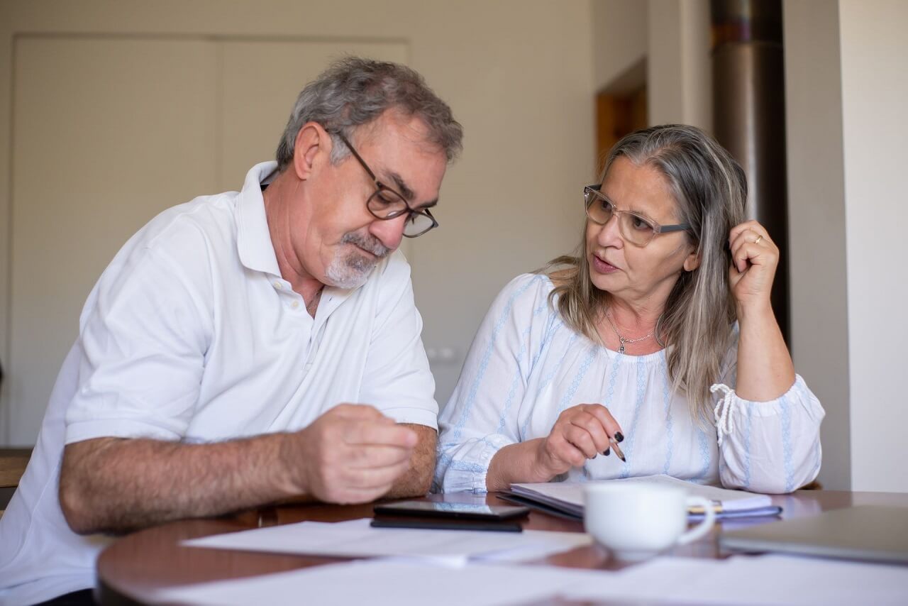 Senior couple working through financial documents at home