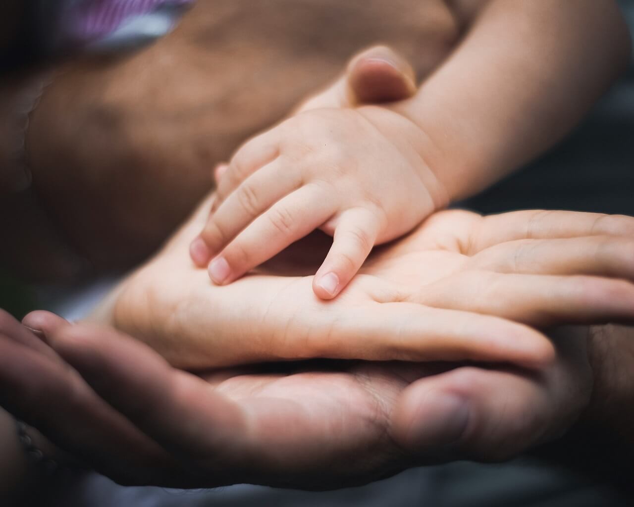babys hand on monther and father palms